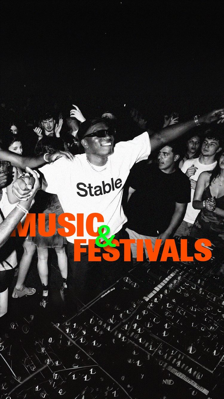 Crowd dancing in front of the DJ booth at a night party, a Stable T-shirt at the centre